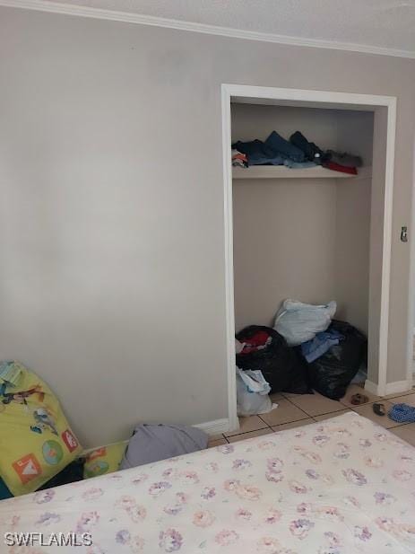 11421 Kimble Dr Unit 423, Fort Myers, FL 33908 - bedroom featuring a closet, crown molding, baseboards, and light tile patterned floors