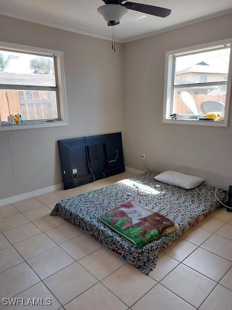 11421 Kimble Dr Unit 423, Fort Myers, FL 33908 - tiled bedroom featuring multiple windows, ornamental molding, baseboards, and ceiling fan