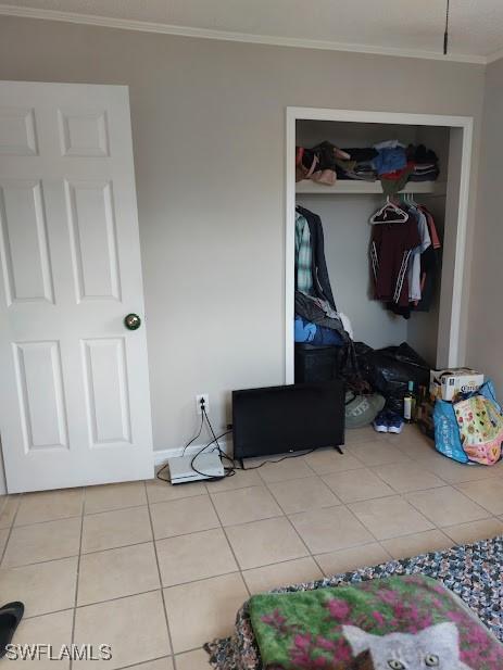 11421 Kimble Dr Unit 423, Fort Myers, FL 33908 - tiled bedroom featuring a closet and crown molding