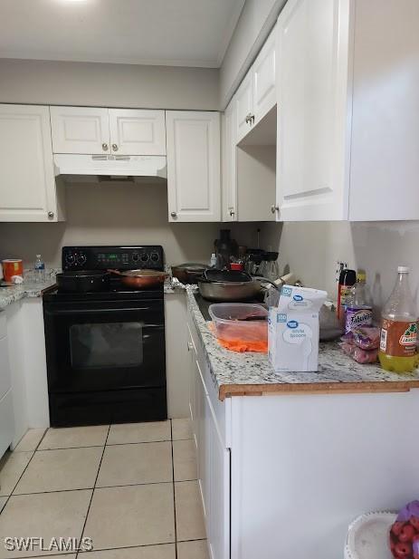 11421 Kimble Dr Unit 423, Fort Myers, FL 33908 - kitchen with black range with electric stovetop, under cabinet range hood, white cabinetry, and light tile patterned floors