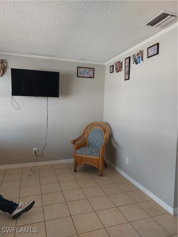 11421 Kimble Dr Unit 423, Fort Myers, FL 33908 - living area with ornamental molding, a textured ceiling, baseboards, and light tile patterned flooring