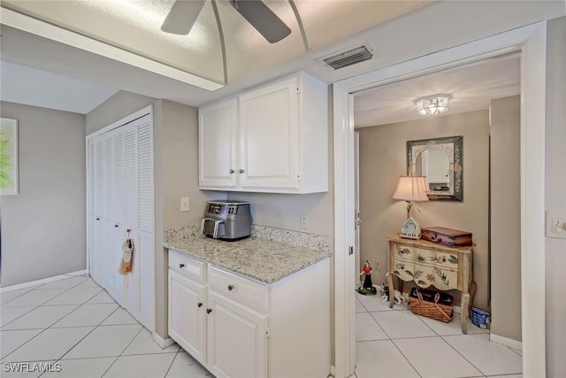 10562 Gulf Shore Dr Unit 402, Naples, FL 34108 - kitchen featuring light tile patterned flooring, white cabinetry, a ceiling fan, and baseboards