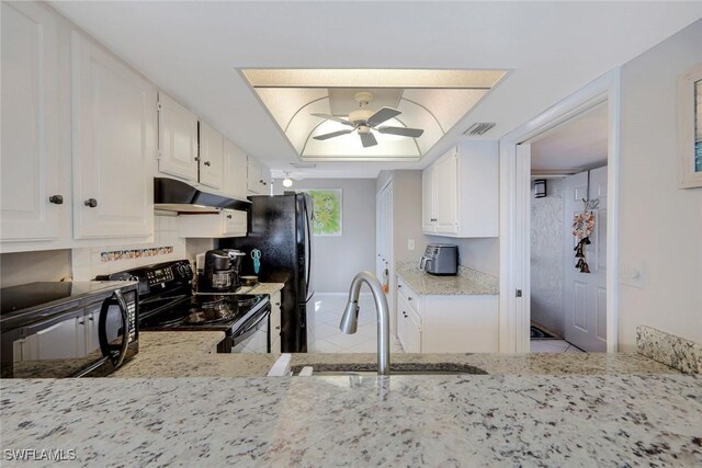 10562 Gulf Shore Dr Unit 402, Naples, FL 34108 - kitchen with black appliances, under cabinet range hood, a sink, light tile patterned floors, and a ceiling fan