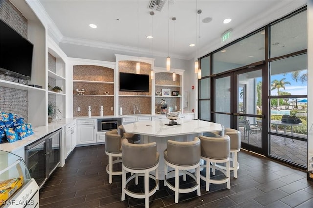 5979 Prosperity Ln, Ave Maria, FL 34142 - kitchen with open shelves, crown molding, stainless steel microwave, french doors, and white cabinets