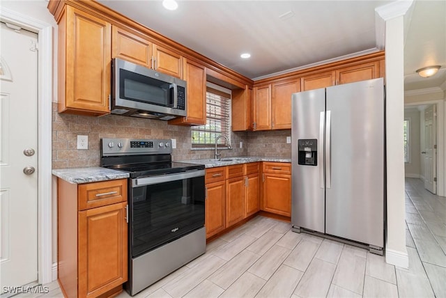 1400 Billie St, Fort Myers, FL 33916 - kitchen featuring stainless steel appliances, a sink, light stone countertops, backsplash, and crown molding