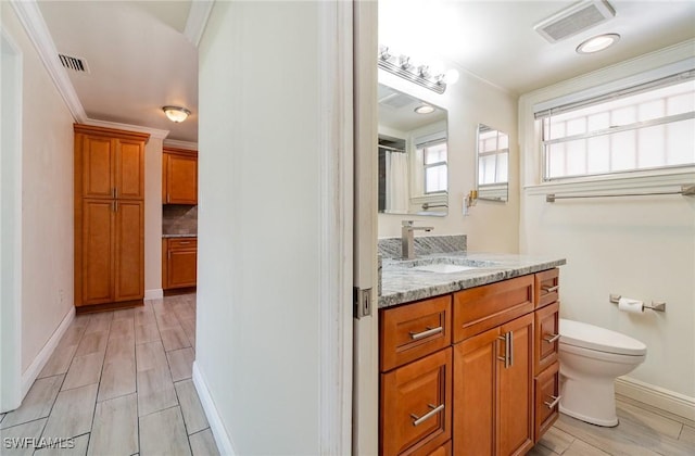 1400 Billie St, Fort Myers, FL 33916 - bathroom with vanity, toilet, wood finished floors, baseboards, and crown molding