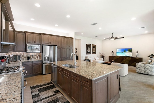 28648 Lobos Cir, Bonita Springs, FL 34135 - kitchen with appliances with stainless steel finishes, a sink, ceiling fan, tasteful backsplash, and an island with sink