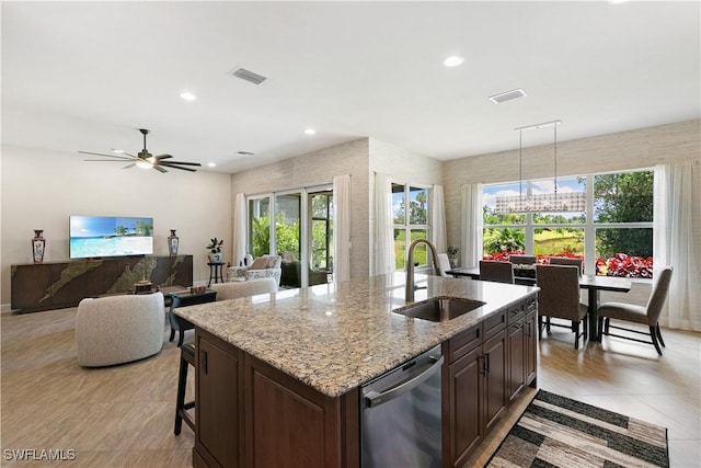 28648 Lobos Cir, Bonita Springs, FL 34135 - kitchen featuring a sink, dishwasher, a kitchen island with sink, light stone countertops, and plenty of natural light