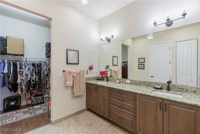 28648 Lobos Cir, Bonita Springs, FL 34135 - bathroom featuring double vanity, baseboards, and a walk in closet