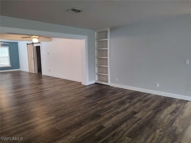 7821 Deni Dr, North Fort Myers, FL 33917 - empty room with built in shelves, dark wood-style floors, and baseboards