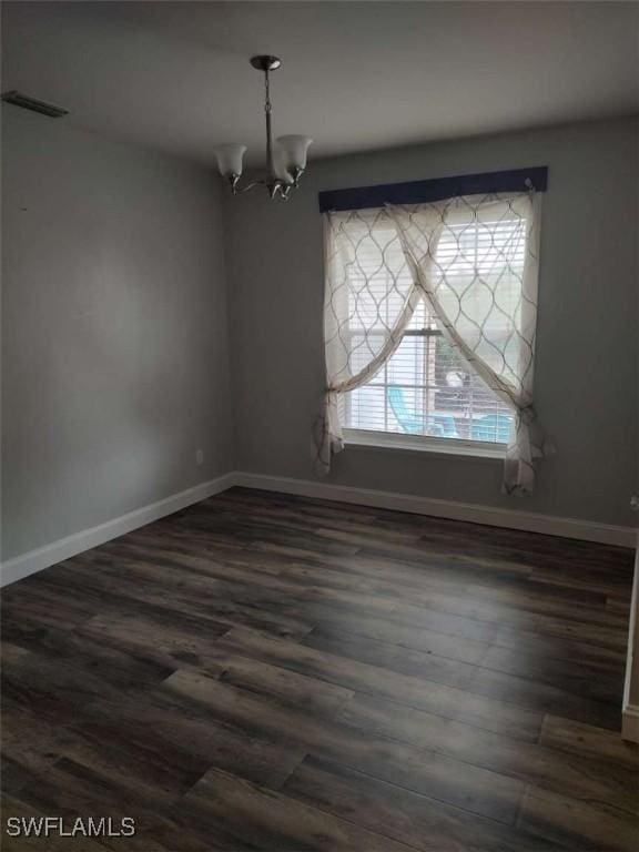7821 Deni Dr, North Fort Myers, FL 33917 - unfurnished room with dark wood finished floors, a chandelier, and baseboards