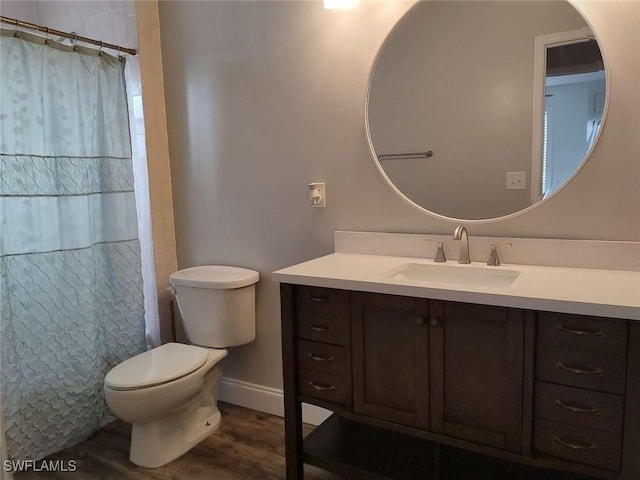 7821 Deni Dr, North Fort Myers, FL 33917 - full bath featuring vanity, toilet, wood finished floors, baseboards, and a shower with shower curtain