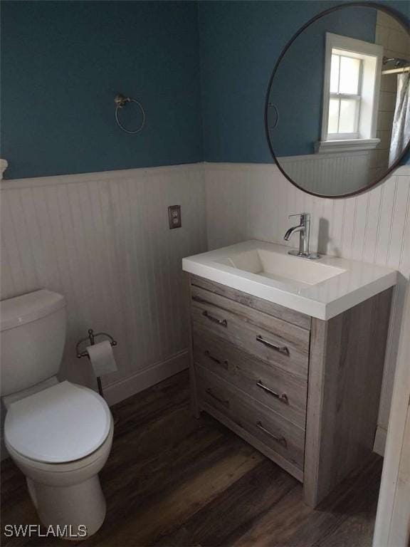 7821 Deni Dr, North Fort Myers, FL 33917 - full bathroom featuring vanity, a wainscoted wall, wood finished floors, toilet, and a shower with curtain