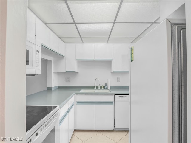 750 W Elkcam Cir Unit 312, Marco Island, FL 34145 - kitchen featuring white appliances, a drop ceiling, white cabinets, light tile patterned flooring, and light countertops