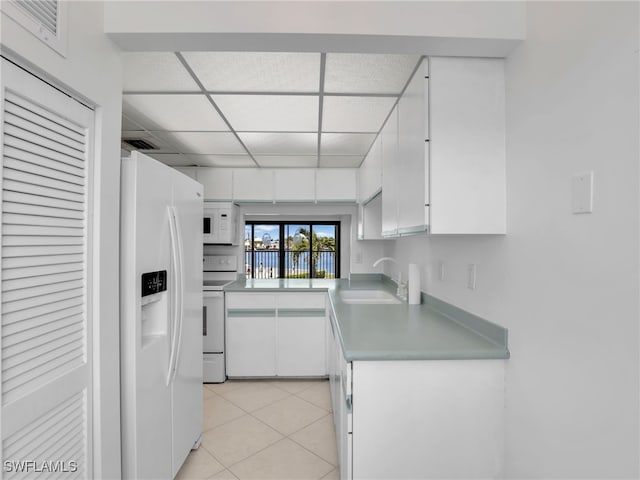 750 W Elkcam Cir Unit 312, Marco Island, FL 34145 - kitchen featuring white appliances, white cabinets, light tile patterned flooring, a drop ceiling, and light countertops