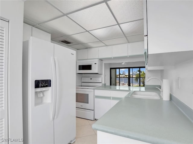 750 W Elkcam Cir Unit 312, Marco Island, FL 34145 - kitchen featuring white appliances, white cabinetry, light tile patterned floors, light countertops, and a paneled ceiling