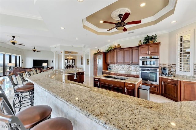 14300 Riva Del Lago Dr Unit 2103, Fort Myers, FL 33907 - kitchen featuring a tray ceiling, ceiling fan, crown molding, black electric stovetop, and decorative backsplash