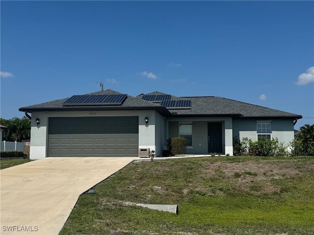1818 NE 6th Pl, Cape Coral, FL 33909 - view of front of house featuring stucco siding, an attached garage, solar panels, concrete driveway, and a front yard