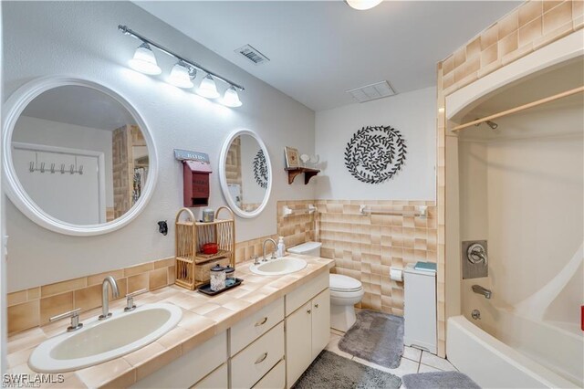 204 Flagler St, Clewiston, FL 33440 - full bathroom with tile walls, bathtub / shower combination, toilet, double vanity, and tile patterned floors