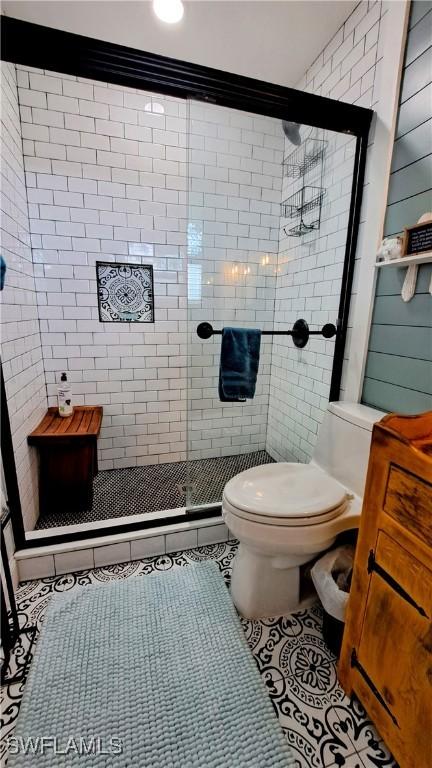 204 Flagler St, Clewiston, FL 33440 - bathroom with tile patterned floors, toilet, a stall shower, and tile walls