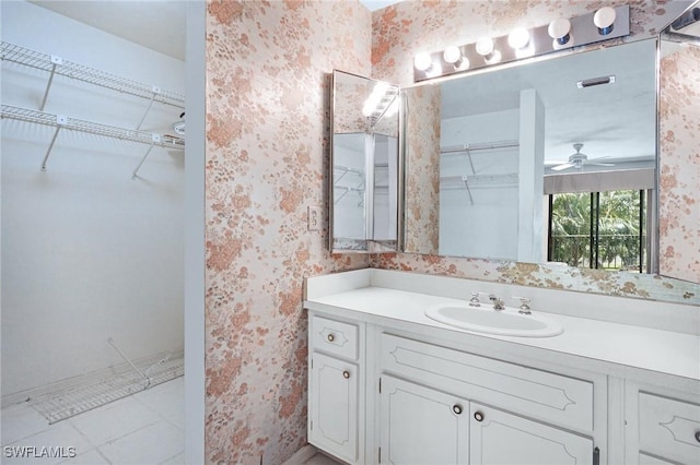 27910 Hacienda E Blvd Unit 201B, Bonita Springs, FL 34135 - bathroom with wallpapered walls, vanity, a walk in closet, a ceiling fan, and baseboards