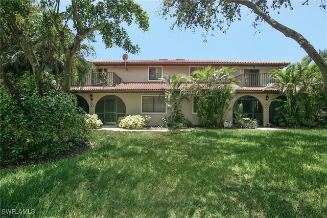 27910 Hacienda E Blvd Unit 201B, Bonita Springs, FL 34135 - mediterranean / spanish house featuring a balcony, stucco siding, a front yard, and a tiled roof