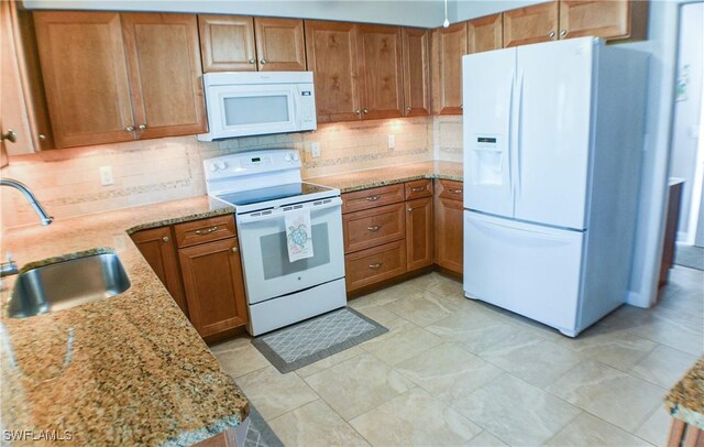 13511 Stratford Place Cir Unit 305, Fort Myers, FL 33919 - kitchen with white appliances, a sink, brown cabinetry, and tasteful backsplash
