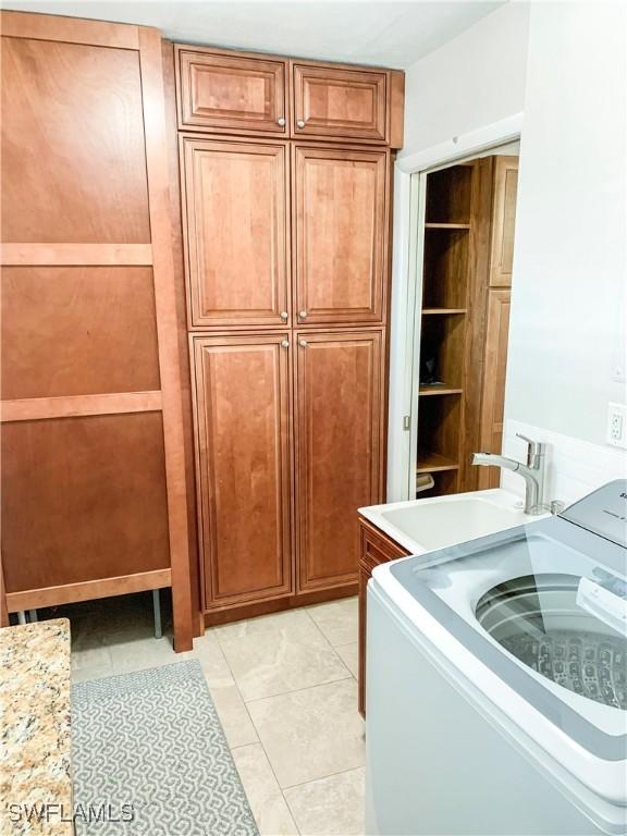 13511 Stratford Place Cir Unit 305, Fort Myers, FL 33919 - laundry room with washer / dryer, cabinet space, and light tile patterned flooring