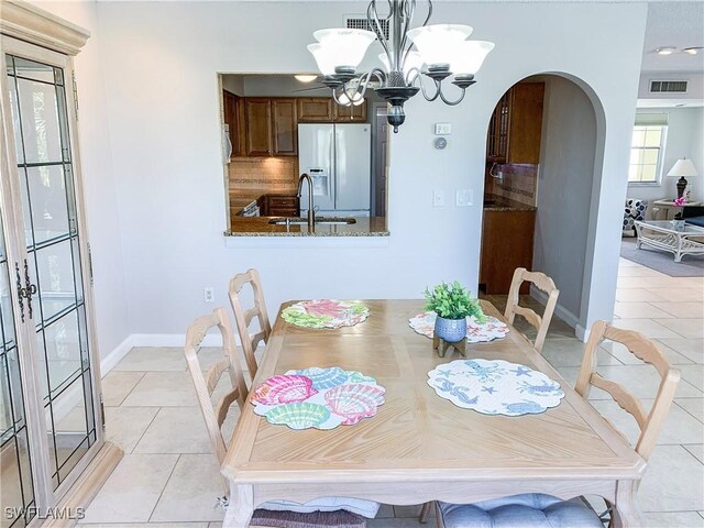 13511 Stratford Place Cir Unit 305, Fort Myers, FL 33919 - dining space with arched walkways, light tile patterned floors, a chandelier, and baseboards