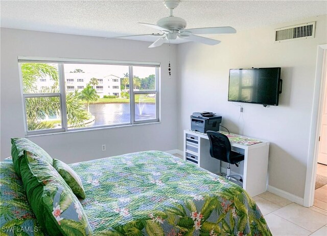 13511 Stratford Place Cir Unit 305, Fort Myers, FL 33919 - bedroom featuring a textured ceiling, light tile patterned floors, a ceiling fan, and baseboards