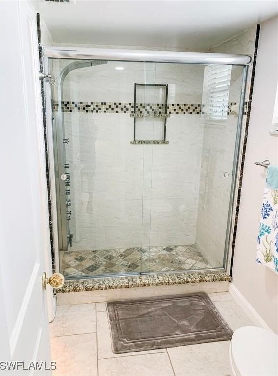 13511 Stratford Place Cir Unit 305, Fort Myers, FL 33919 - bathroom with toilet, a stall shower, and tile patterned floors