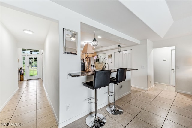 4665 47th Ave NE, Naples, FL 34120 - kitchen featuring a kitchen breakfast bar, light tile patterned floors, and a peninsula