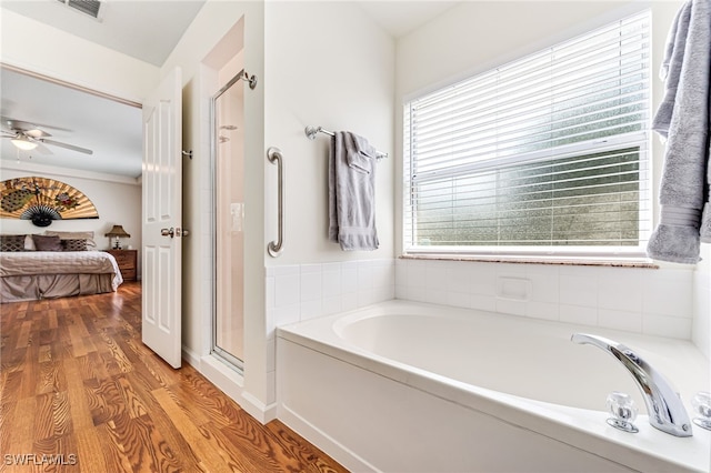 4665 47th Ave NE, Naples, FL 34120 - ensuite bathroom with wood finished floors, a garden tub, a stall shower, and a ceiling fan