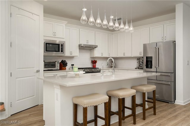 42530 Atlas Dr, Punta Gorda, FL 33982 - kitchen featuring stainless steel appliances, white cabinetry, light wood-style flooring, and decorative backsplash