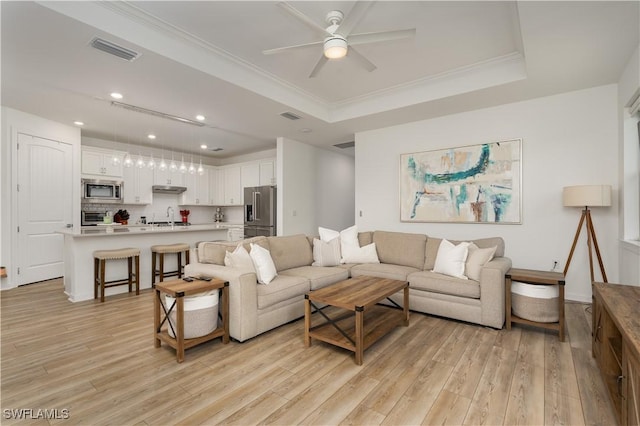 42530 Atlas Dr, Punta Gorda, FL 33982 - living room featuring light wood-type flooring, a tray ceiling, ceiling fan, recessed lighting, and ornamental molding