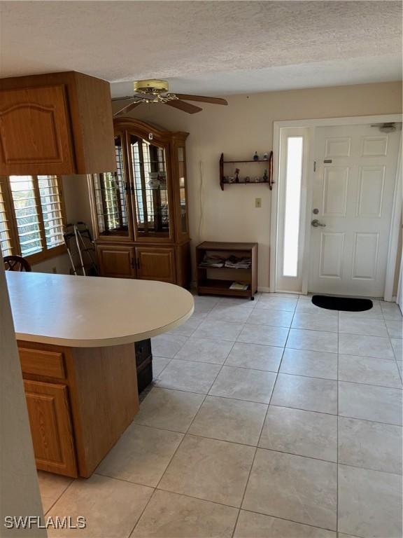 4210 SE 19th Ave Unit 2J, Cape Coral, FL 33904 - foyer entrance featuring a ceiling fan, light tile patterned floors, and a textured ceiling