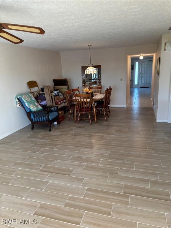 4210 SE 19th Ave Unit 2J, Cape Coral, FL 33904 - dining area with a ceiling fan, baseboards, light wood-style floors, and a textured ceiling