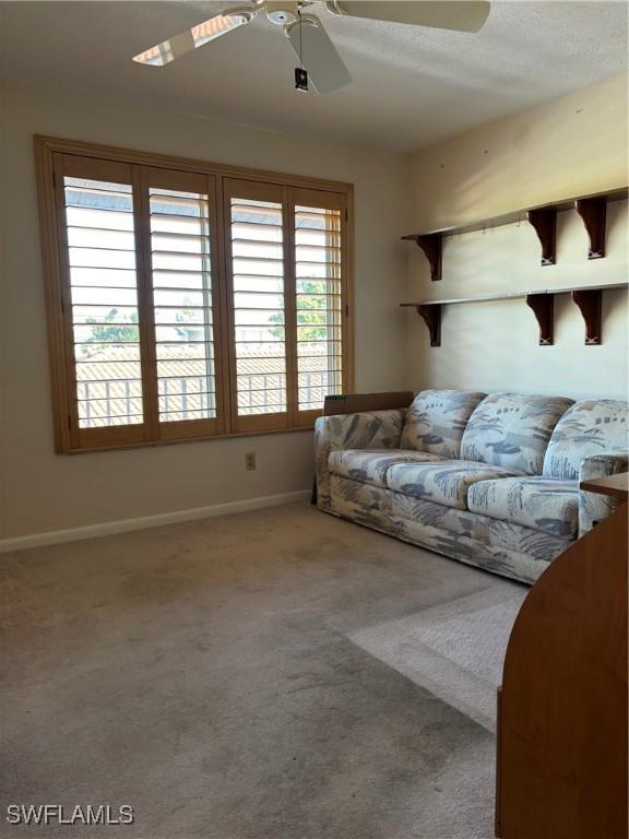 4210 SE 19th Ave Unit 2J, Cape Coral, FL 33904 - carpeted living room featuring a ceiling fan and baseboards
