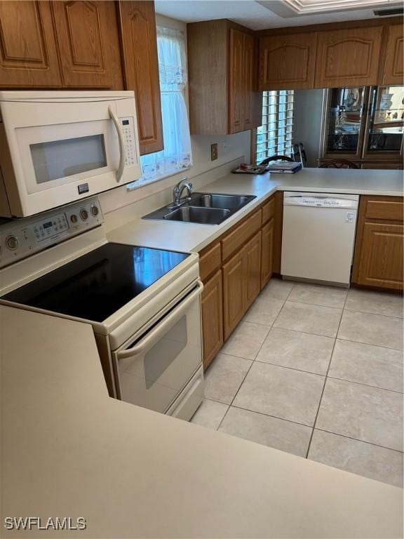 4210 SE 19th Ave Unit 2J, Cape Coral, FL 33904 - kitchen featuring white appliances, a sink, light countertops, and brown cabinets