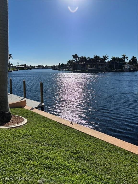 4210 SE 19th Ave Unit 2J, Cape Coral, FL 33904 - dock with a water view and a lawn