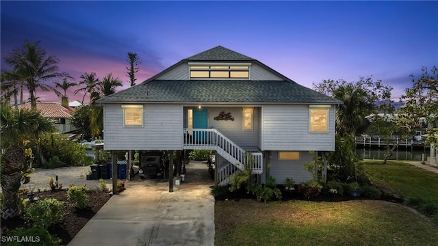 3627 Clipper Ln, Saint James City, FL 33956 - coastal home featuring a carport, a shingled roof, driveway, stairway, and a yard