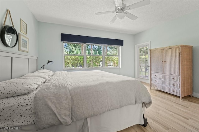 1044 Woodshire Ln Unit B102, Naples, FL 34105 - bedroom featuring a textured ceiling, light wood-style flooring, and a ceiling fan