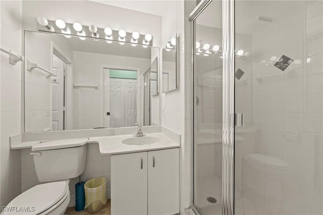 1044 Woodshire Ln Unit B102, Naples, FL 34105 - bathroom featuring toilet, a shower stall, vanity, and tile walls