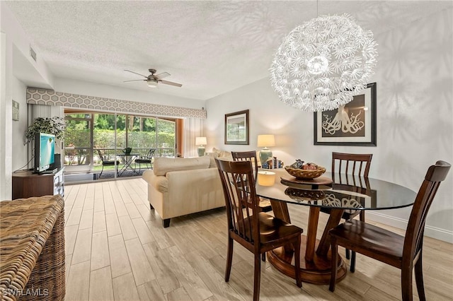1044 Woodshire Ln Unit B102, Naples, FL 34105 - dining area with light wood-style floors, a textured ceiling, ceiling fan, and a chandelier