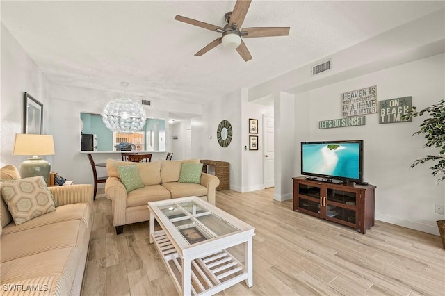 1044 Woodshire Ln Unit B102, Naples, FL 34105 - living room featuring a chandelier, ceiling fan, light wood-style floors, and baseboards