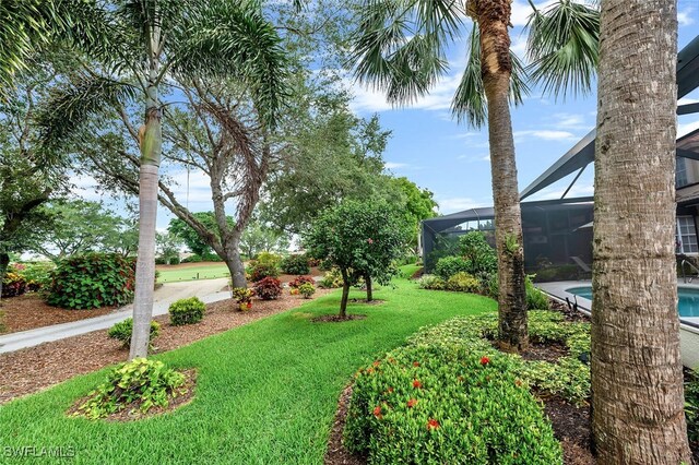 28686 San Galgano Way, Bonita Springs, FL 34135 - view of grassy yard with an outdoor pool and glass enclosure