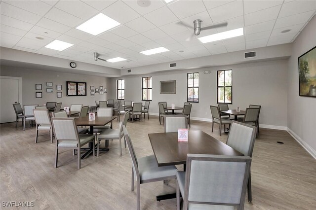 28686 San Galgano Way, Bonita Springs, FL 34135 - dining space with a drop ceiling, light wood-style floors, and baseboards