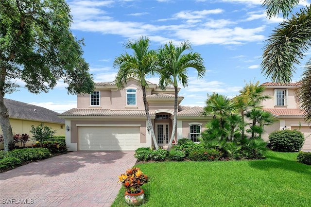 28686 San Galgano Way, Bonita Springs, FL 34135 - mediterranean / spanish-style house with decorative driveway, stucco siding, a front lawn, a garage, and a tiled roof