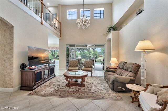 28686 San Galgano Way, Bonita Springs, FL 34135 - living room featuring arched walkways, a high ceiling, a chandelier, a ceiling fan, and baseboards