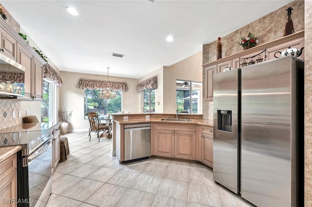 28686 San Galgano Way, Bonita Springs, FL 34135 - kitchen featuring appliances with stainless steel finishes, a sink, a peninsula, tasteful backsplash, and light tile patterned floors